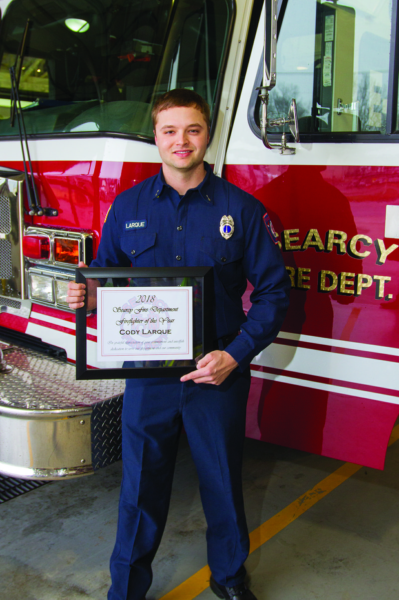 Cody Larque, the 2018 Searcy Fire Department Firefighter of the Year, holds his award while standing in front of a truck inside the Fire Department. Larque, who is a lieutenant in the department, is a 2011 graduate of Searcy High School and has worked for the department since 2014.
