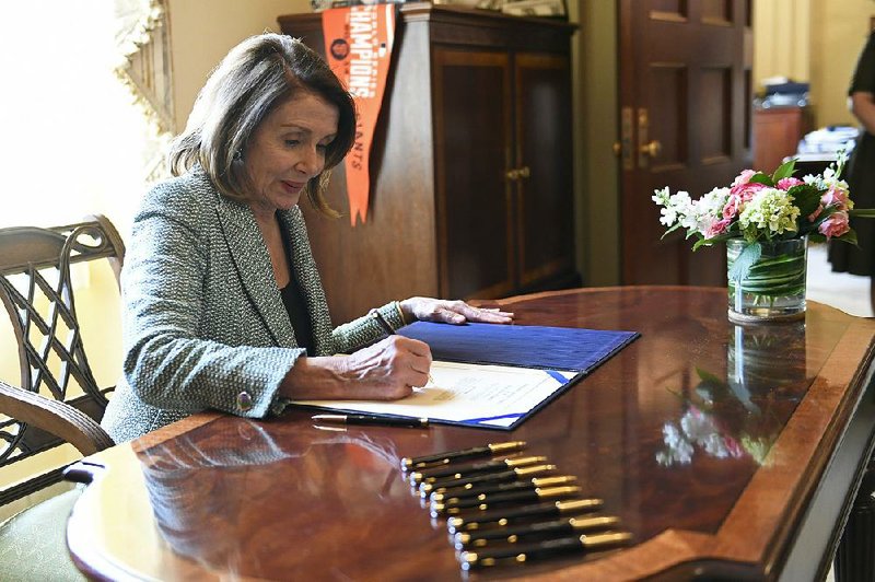 House Speaker Nancy Pelosi signs the resolution rejecting President Donald Trump’s border emergency declaration after the Senate approved the measure. The House had already given its approval. 