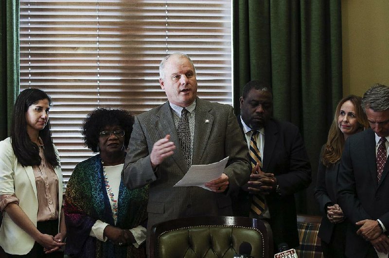 Senate President Pro Tempore Jim Hendren, surrounded by Democratic and Republican lawmakers Thursday at the state Capitol, presents details of his tax-cut plan for low- and moderate-income families. More photos are available at arkansasonline.com/315genassembly/. 