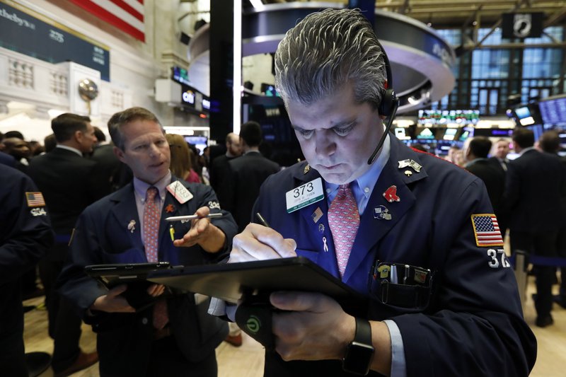 FILE- In this March 11, 2019, file photo trader John Panin, right, works on the floor of the New York Stock Exchange. The U.S. stock market opens at 9:30 a.m. EDT on Thursday, March 14. (AP Photo/Richard Drew, File)