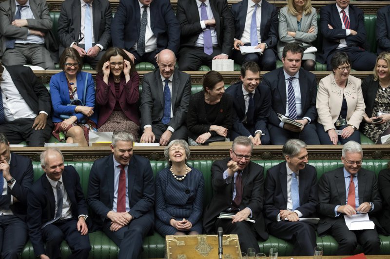 In this handout photo provided by UK Parliament, Britain's Prime Minister Theresa May, first row centre, laughs during the Brexit debate in the House of Commons, London, Thursday March 14, 2019. Britain's Parliament has voted to seek a delay of the country's departure from the European Union, a move that will likely avert a chaotic withdrawal on the scheduled exit date of March 29. (UK Parliament/Jessica Taylor via AP)