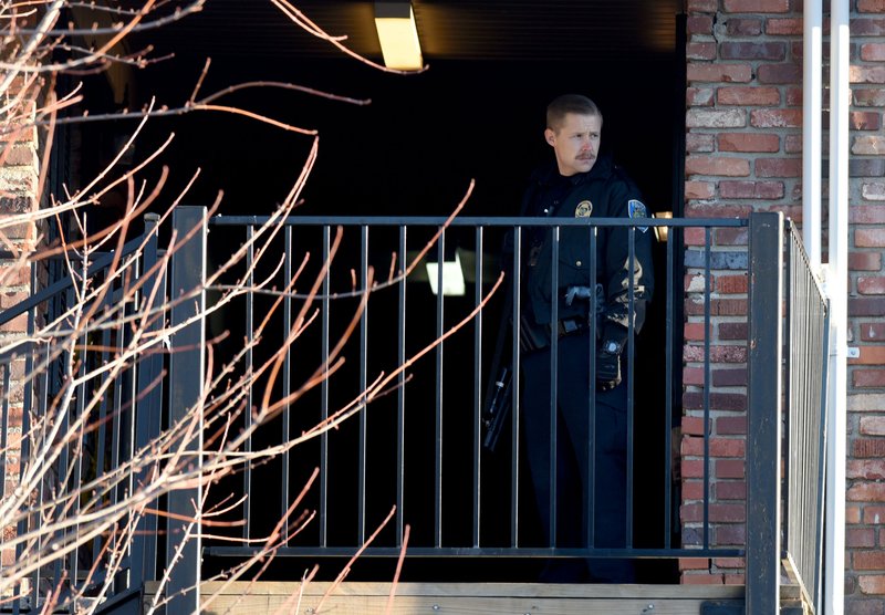 NWA Democrat-Gazette/DAVID GOTTSCHALK A Fayetteville Police Officer stands watch this morning on the third floor of an apartment unit at South Creekside Apartments, 900 N. Leverett Ave. in Fayetteville.