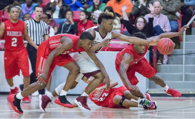 Magnolia’s Derrian Ford (left), Colby Garland (floor) and Kadyn Roach (right) fight for a ball against a Blytheville player during the state tournament. All three received Class 4A state recognition for their efforts during the tournament.