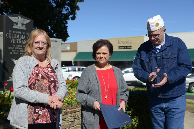 American Legion Post 3 Commander Linda Webb (left) and Legion Vice Commander Brian Burdine (right) clap after a special proclamation was read by County Clerk Tammy Wiltz on Friday in front of the Columbia County Veterans Memorial to commemorate the centennial anniversary of the American Legion organization.