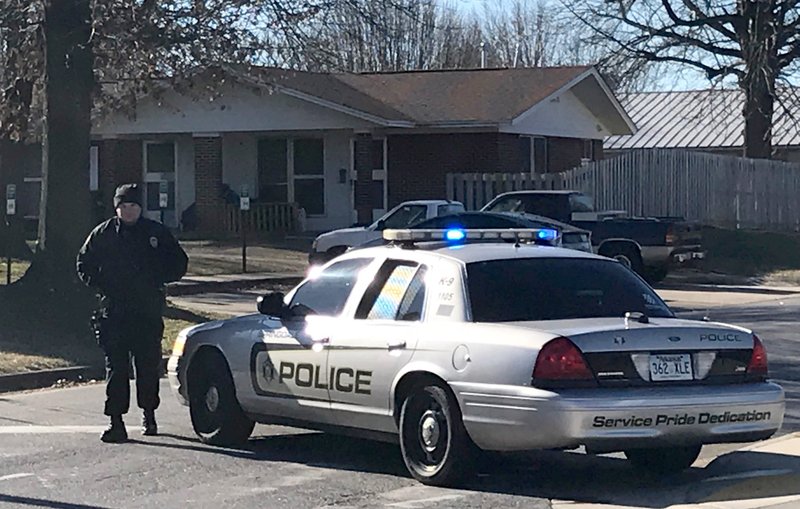 A Springdale police officer blocks an intersection at Caudle Avenue and Applegate Drive outside the Springdale Housing Authority in Springdale. 