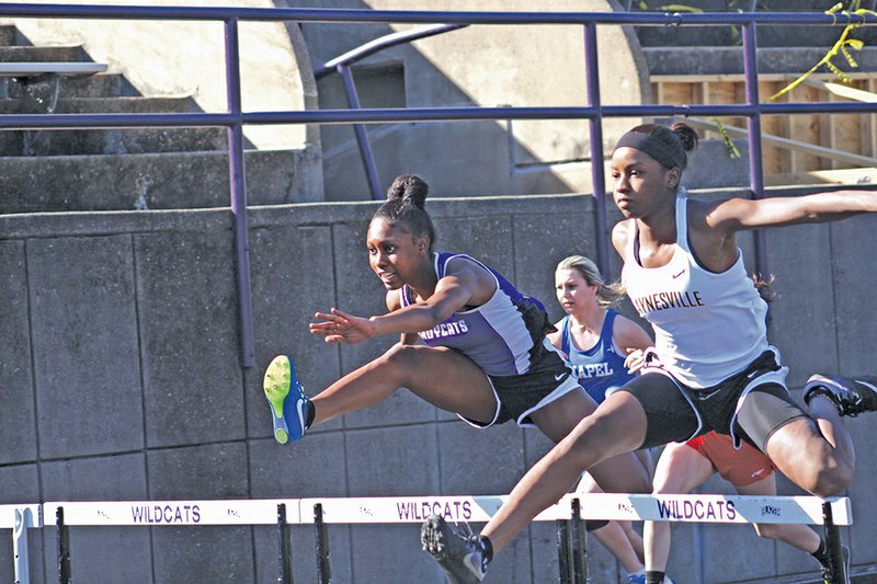 Michael Shine/News-Times El Dorado's Breya Clark leaps over a hurdle during the 100-meter hurdles race at the Oil Belt Relays Thursday at Memorial Stadium. Clark won the race. Haynesville's Marissa Tell (right) finished second.