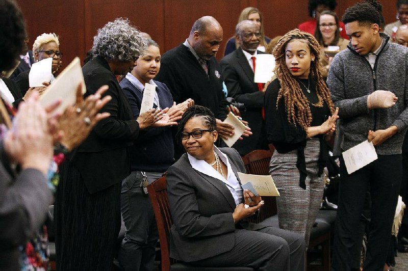 Lisa G. Peters (center) is applauded as she is introduced during her investiture as the federal public Defender for the Eastern District of Arkansas on Friday at the Richard Sheppard Arnold United States Courthouse in Little Rock. More photos are available at www.arkansasonline.com/316fedcourt/. 