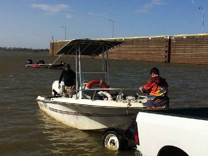 A trio of cat fishermen prepare to brave high wind and heavy current on the Arkansas River Thursday at David D. Terry Lock and Dam.