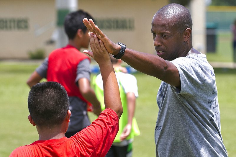 In a September 2016 photo, Yale's women's Head Soccer Coach Rudy Meredith gives a high five to a player after making a great play in a scrimmage, in Frankfort, Ky. According to the federal indictments unsealed Tuesday, March 12, 2019, Meredith put a prospective student who didn't play soccer on a school list of recruits, doctored her supporting portfolio to indicate she was a player, and later accepted $400,000 from the head of a college placement company. (Doug Engle/Star-Banner via AP)