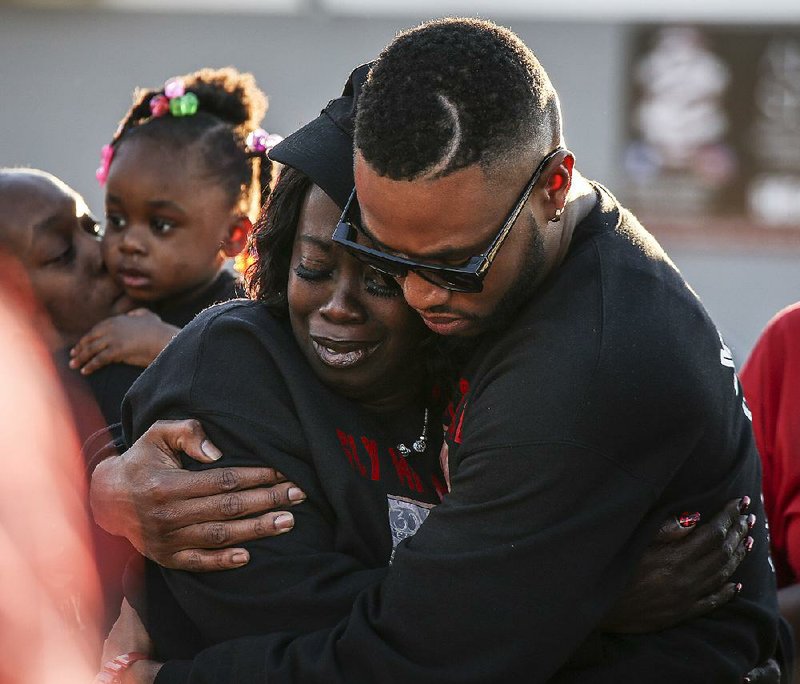 Kimberly Blackshire-Lee, mother of Bradley Blackshire, embraces his cousin Montrell Ussery during a vigil Saturday in Little Rock at the spot where her son died. About 50 people gathered as Blackshire-Lee called for justice and community activism. 