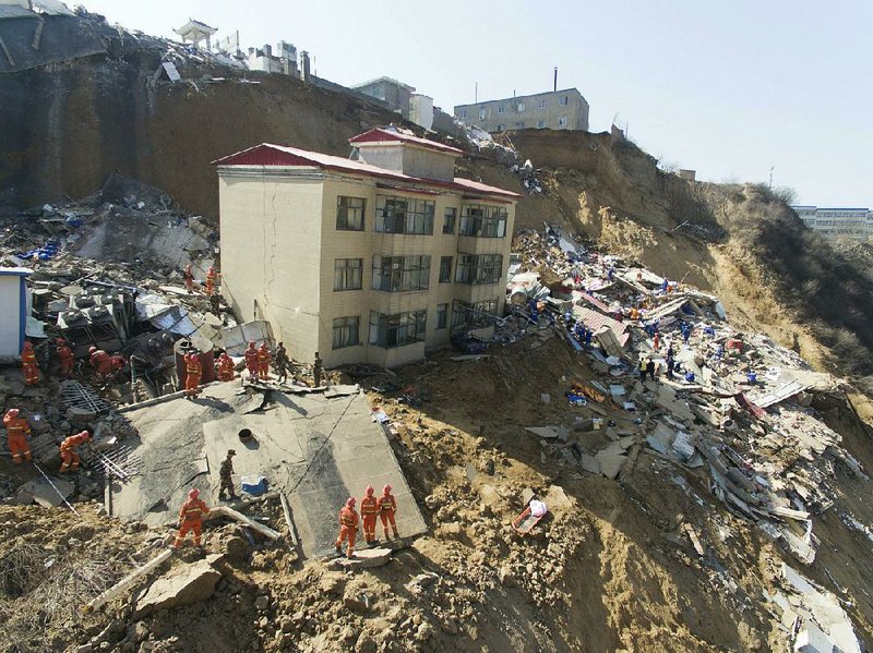 Rescue workers search Saturday in the rubble left by a landslide in China’s Shanxi province. 