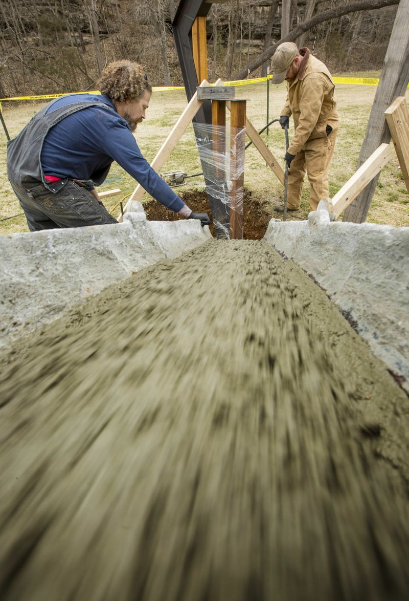 NWA Democrat-Gazette/BEN GOFF Corey Milford (left) and Eric Wolski with Milford Sign Company pour concrete March 7 for a new sign at Blowing Springs Park in Bella Vista. The sign will welcome visitors to the new Bella Vista Arboretum.