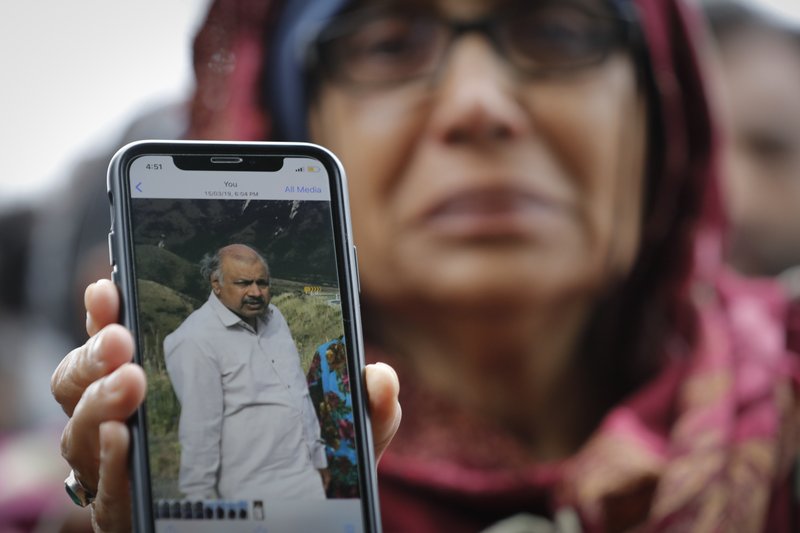 Akhtar Khokhur, 58, shows a picture of her missing husband Mehaboobbhai Khokhar during an interview outside an information center for families, Saturday, March 16, 2019, in Christchurch, New Zealand. The white supremacist gunman appeared in court Saturday charged with murder in the mosque assaults that killed at least 49 people and led to the prime minister to call for a tightening of national gun laws. (AP Photo/Vincent Thian)