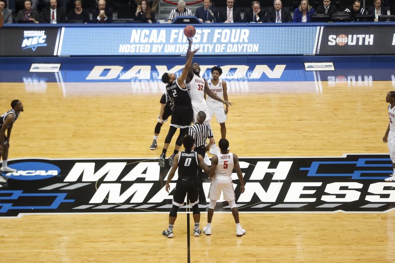 FILE - In this March 13, 2018, file photo, Radford's Randy Phillips (32) and LIU Brooklyn's Julius van Sauers (2) tip off during the first half of a First Four game of the NCAA men's college basketball tournament, in Dayton, Ohio. Dayton stages the four play-in games over two nights, assuring the city and the private University of Dayton a nice slice of the NCAA Tournament pie every March. The city will host the event at least through 2022 after beating out Detroit and Evansville, Indiana, for the current four-year contract. (AP Photo/John Minchillo, File)