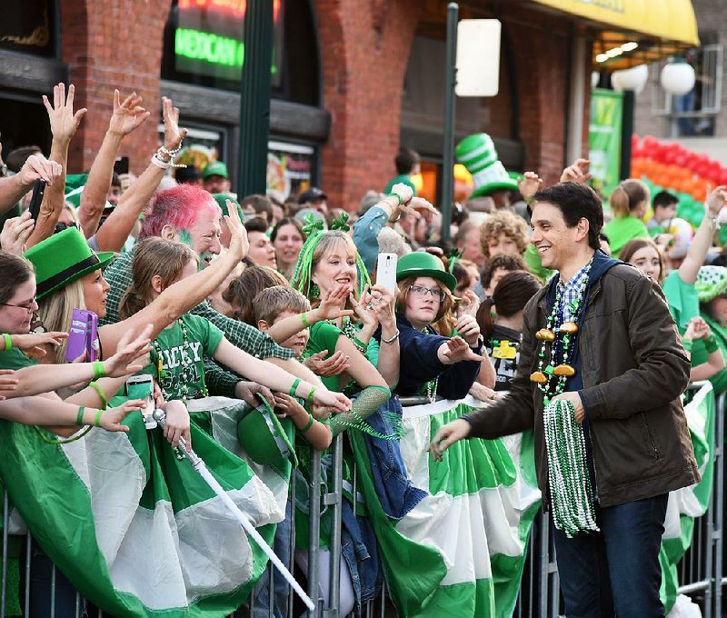 Grand marshal Ralph Macchio greets paradegoers and hands out beaded necklaces Sunday evening during the First Ever 16th Annual World’s Shortest St. Patrick’s Day Parade. More photos are available at arkansasonline.com/318parade/. 