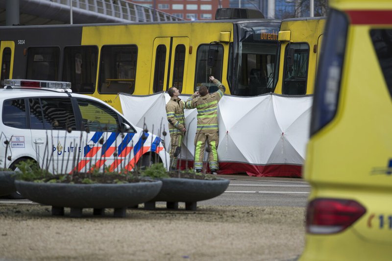 Rescue workers install a screen on the spot where a human shape was seen under a white blanket following a shooting in Utrecht, Netherlands, Monday, March 18, 2019. Police in the central Dutch city of Utrecht say on Twitter that "multiple" people have been injured as a result of a shooting in a tram in a residential neighborhood. (AP Photo/Peter Dejong)