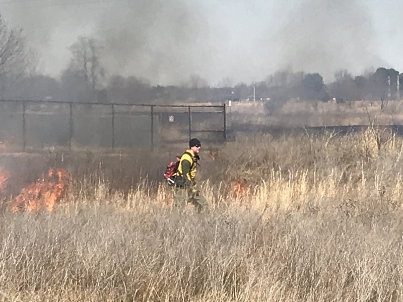 A worker walks through a control burn area Monday, March 18, 2019 on the Woolsey Wet Prairie Sanctuary in Fayetteville. 