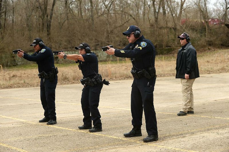 Instructor Terry Tate (right) gives commands March 7, as officers Andy Nuez (from left), Clarisa Navarro, and Cpl. Aaron Tomlinson, all of the Fayetteville Police Department, train at the department’s gun range in south Fayetteville. About $35 million for a new police headquarters and $3 million in improvements to public buildings is included in a bond referendum Fayetteville voters will consider April 9. 