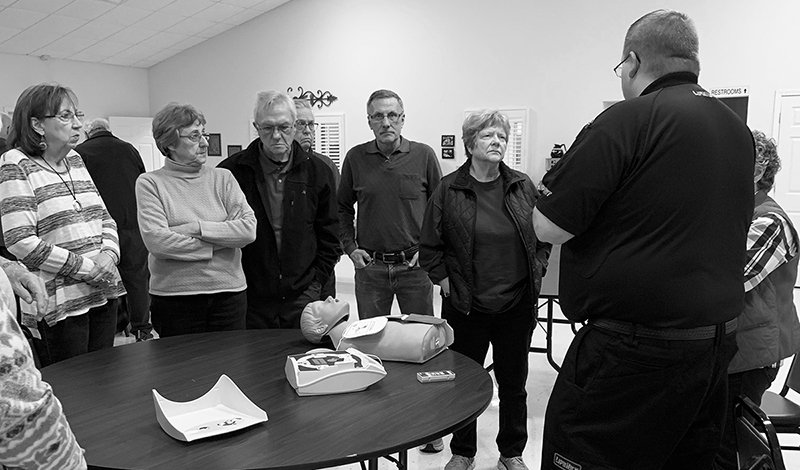 Submitted photo LIFESAVING LESSONS: Diamondhead community members listen to LifeNet QI Manager Daniel Stramp, far right, answer a question about how to apply an automated external defibrillator, or AED, during the hands-on portion of a free bystander CPR and AED class held March 7 at Diamondhead Community Church. Lake Hamilton Fire and Rescue assisted with teaching the hands-on portion of the class.