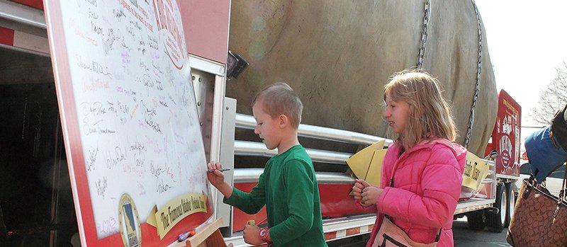 The Sentinel-Record/Richard Rasmussen SIGNING UP: Allen Wetzler, 6, left, and Lorelei Wetzler, 8, of Hot Springs, on Monday sign a signature board set up next to The Famous Idaho Potato Tour at Hill Wheatley Plaza.