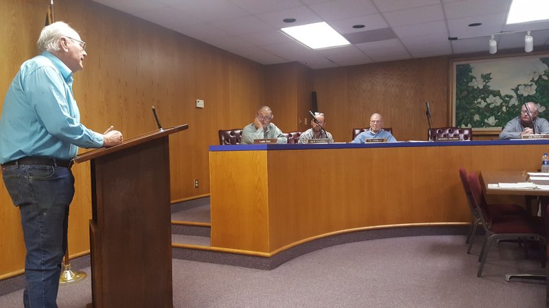 Former property owner Tim Hampton (left) on Monday speaks to the Magnolia Planning Commission in favor of a variance at 605 N. Dudney Street granting an auto body shop to operate at the former Hampton Auto Maintenance. Hampton was one of numerous speakers in favor of the variance that ultimately failed approval by a 4-2 commission vote. Also pictured (seated L-R) are Commissioners Leslie Kent, Nate Caldwell, T.G. Connelly, and Chairman Joe Pieratt. Not pictured are Commissioners Mary Iverson, Julia Nipper, and Calvin Daniel.