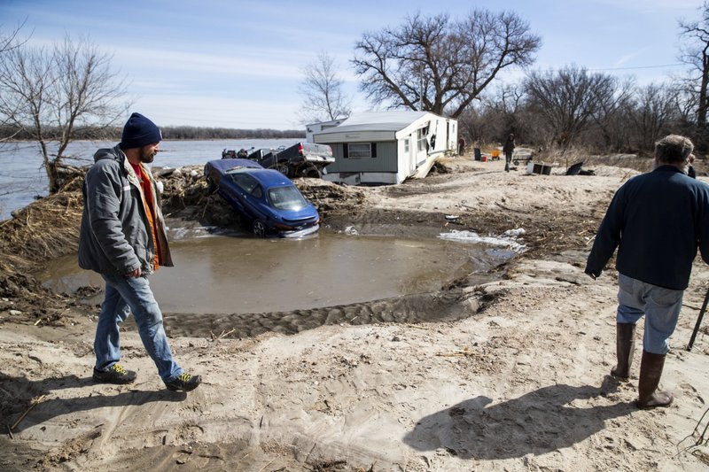 Tim Rockford, left, and David Bauer, tour the Bellwood Lakes neighborhood Monday, March 18, 2019, in Bellwood, Neb. Much of the area was heavily impacted by flooding along the Platte River. (Brendan Sullivan/Omaha World-Herald via AP)

