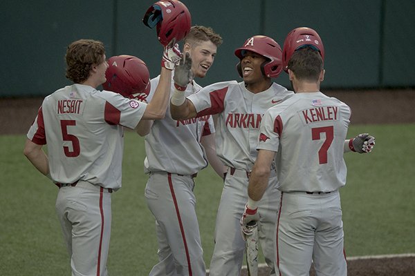 Arkansas outfielder Christian Franklin (25) celebrates a grand slam with infielder Jacob Nesbit (5) during an NCAA college baseball game against Texas, Tuesday, March 19, 2019, in Austin, Texas. (Nick Wagner/Austin American-Statesman via AP)