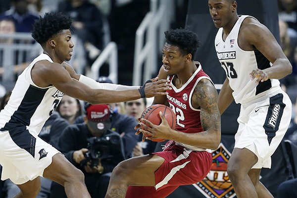 Arkansas' Gabe Osabuohien (22) struggles to keep control of the ball against Providence's David Duke (3) and Kalif Young (13) during the first half of a first round NCAA National Invitation Tournament college basketball game in Providence, R.I., Tuesday, March 19, 2019. (AP Photo/Michael Dwyer)

