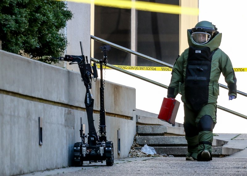 El Dorado Sgt. Jarod Primm walks towards a suspicious package outside of the Bi-State Justice Building in his Explosive Ordnance Disposal suit on Monday in Texarkana, Texas. The Bi-State Justice Building was evacuated about 9:40 a.m. Monday and a bomb squad was called to investigate the report of a "suspicious package" outside of the building, an official said. Hunt Mercier/Texarkana Gazette