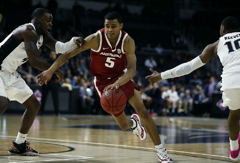 Arkansas’ Jalen Harris (right) drives past Providence’s Maliek White during the second half of the teams’ first-round NIT game Tuesday in Providence, R.I. Harris had 7 points, 6 assists, 5 rebounds and 3 steals as the Razorbacks won 84-72. More photos are available at arkansasonline.com/galleries. 