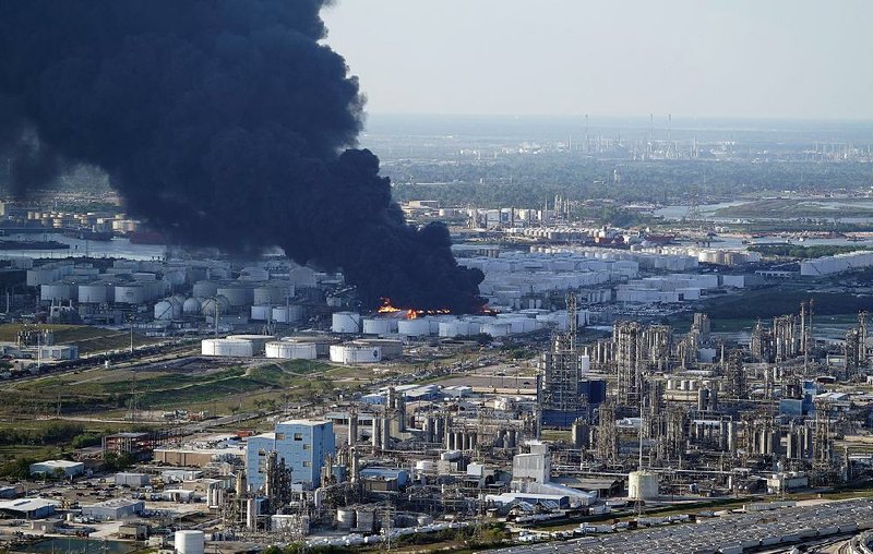 Dark smoke billows from a petrochemical fire outside Houston in this aerial photo taken Monday. The fire continued to burn intensely enough Tuesday to create its own weather system, causing shifting winds, officials said. 