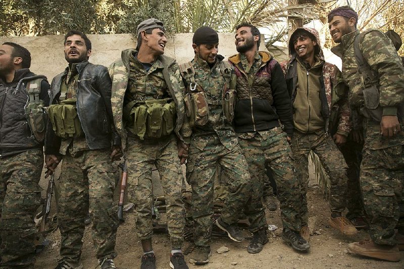 U.S.-backed Syrian Democratic Forces fighters celebrate their territorial gains Tuesday over Islamic State militants in Baghouz, Syria. 