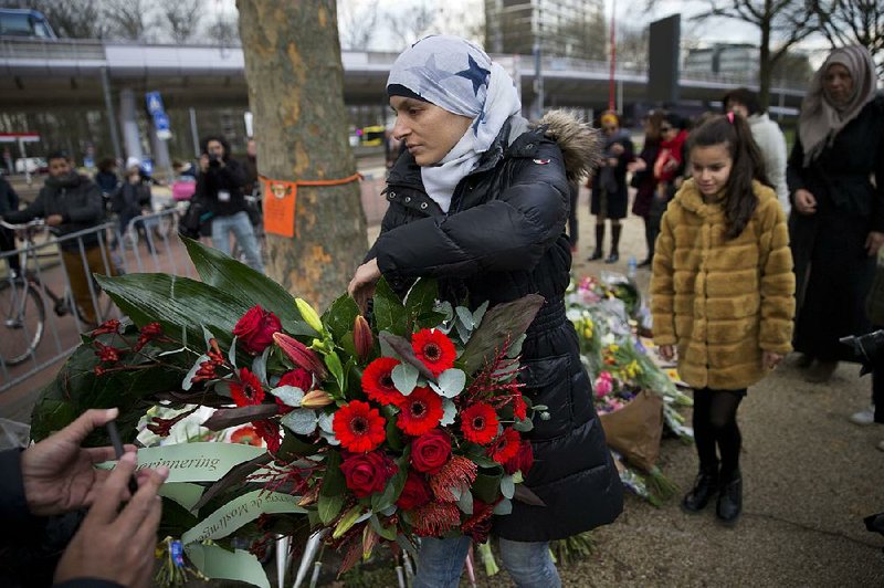 Women representing the Muslim community in Utrecht, Netherlands, places a wreath Tuesday at a makeshift memorial for victims of Monday’s tram shooting. 