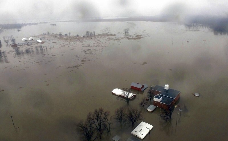 This Tuesday, March 19, 2019 aerial photo shows flooding along the Missouri River in Pacific Junction, Iowa. The U.S. Army Corps of Engineers says rivers breached at least a dozen levees in Nebraska, Iowa and Missouri. Hundreds of homes are damaged, and tens of thousands of acres are inundated with water. (DroneBase via AP)