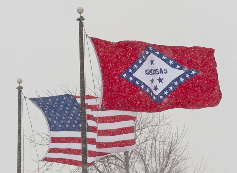 In this Feb. 1, 2011, file photo, an American and Arkansas flag blow in the wind as snow falls in Fayetteville, Ark. An Arkansas House panel on Wednesday rejected for a second time a proposal to change the meaning of a star on the state’s flag that currently represents the Confederacy, despite an endorsement from the Republican governor. (AP Photo/Beth Hall, File)

