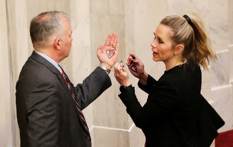 On Wednesday, Sen. Breanne Davis, R-Russellville, draws a heart on the hand of Lt. Gov. Tim Griffin in a show of support for people who have Down syndrome. The Senate adopted Davis’ resolution on World Down Syndrome Day. Senators also approved a bill banning abortions of fetuses with the genetic disorder. More photos at arkansasonline.com/321genassembly/ 