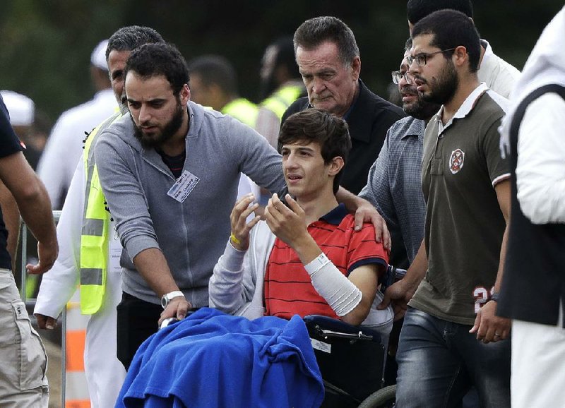 Zaed Mustafa, 13, attends the burial of his father, Khalid Mustafa, and brother Hamza, 15, at a cemetery Wednesday in Christchurch, New Zealand. Zaed suffered arm and leg wounds when a gunman opened fire at their mosque. 