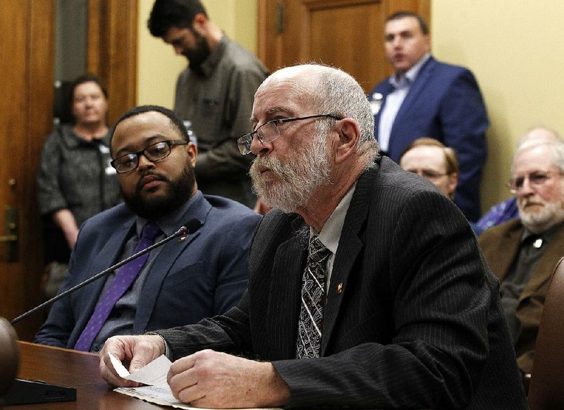 House Minority Leader Charles Blake (left) listens as Loy Mauch of Bismarck, among others, speaks against his bill to redesignate a star on the state flag. The bill failed to get out of committee for the second time, but Blake said he might try to revive it in the Senate. More photos are available at arkansasonline.com/321genassembly/. 