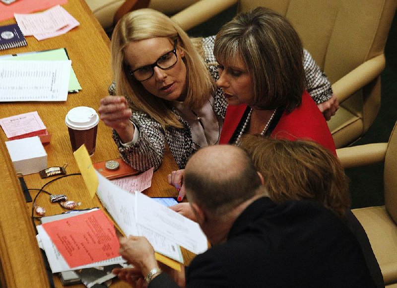 Rep. DeAnn Vaught (left) talks with Rep. Sarah Capp on Wednesday in the House. More photos are available at arkansasonline.com/321genassembly/.