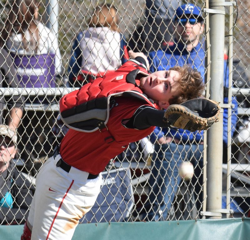 RICK PECK/SPECIAL TO MCDONALD COUNTY PRESS McDonald County catcher Joe Brown reaches for a foul pop-up during the Mustangs' 11-0 win over Westside High School of Jonesboro, Ark., in the fifth-place game of the Ozark Baseball Classic on March 16 in Harrison, Ark.