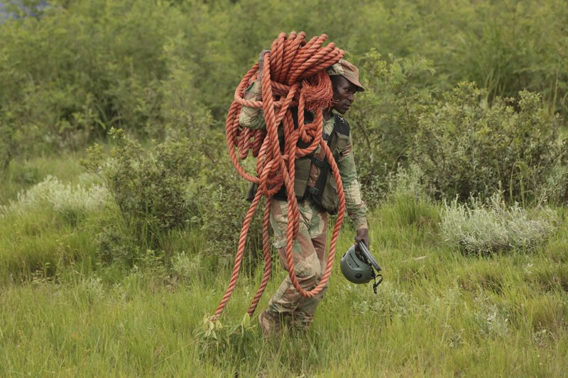 A soldier carries a rope during a rescue operation in Chimanimani about 600 kilometres south east of Harare, Zimbabwe, Tuesday, March 19, 2019. According to the government Cyclone Idai has killed more than 100 people in Chipinge and Chimanimani and according to residents the figures could be higher because the hardest hit areas are still inaccessible. Some hundreds are dead, and many more still missing with many thousands at risk from massive flooding in the region of Mozambique, Malawi and Zimbabwe caused by Cyclone Idai. (AP Photo/Tsvangirayi Mukwazhi)