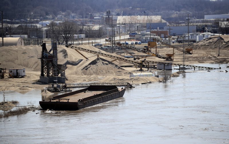 A barge is moored along the Missouri River as floodwaters begin to creep into a dredge operation in St Joseph, Mo., Monday, March 18, 2019. (AP Photo/Orlin Wagner)