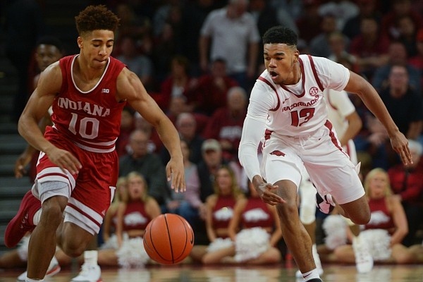 Arkansas Razorbacks guard Mason Jones (13) and Indiana Hoosiers guard Rob Phinisee (10) reach for the ball during a basketball game, Sunday, November 18, 2018 at Bud Walton Arena in Fayetteville.