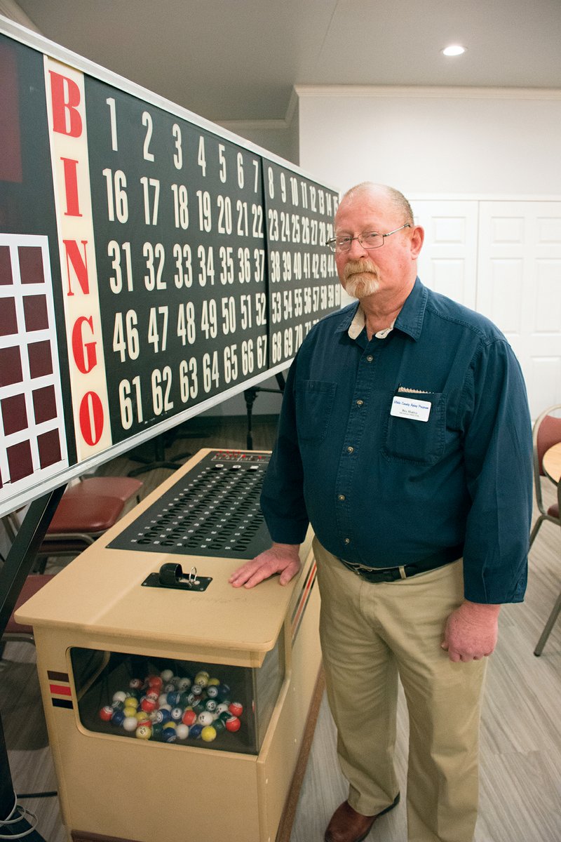 Bill Hartle, the new program director for the White County Aging Program, stands next to the bingo board at the Lightle Center in Searcy. Hartle worked in the grocery business for 40 years and in safety inspection for a few years before retiring, then getting the job with the senior program in Searcy.
