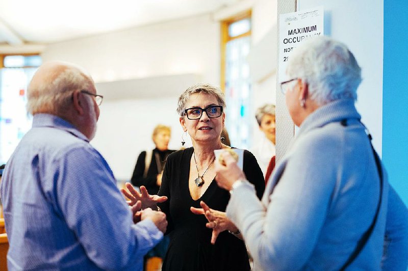 The Rev. Gretta Vosper, a minister at the West Hill United Church, speaks with her parishioners Jim and Louise Thompson after her service in Toronto. Vosper has stayed in the United Church despite rejecting the idea of a supernatural being, instead emphasizing love, justice and compassion. 