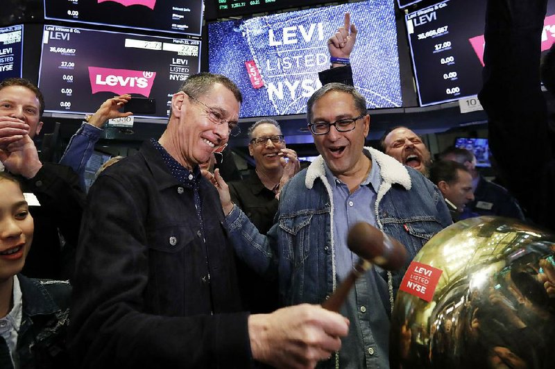 Levi Strauss Chief Executive Officer Chip Bergh (left) is joined by Chief Financial Officer Harmit Singh as he rings a ceremonial bell Thursday when his company’s initial public offering begins trading on the New York Stock Exchange. Video at arkansasonline.com/322levi/ 