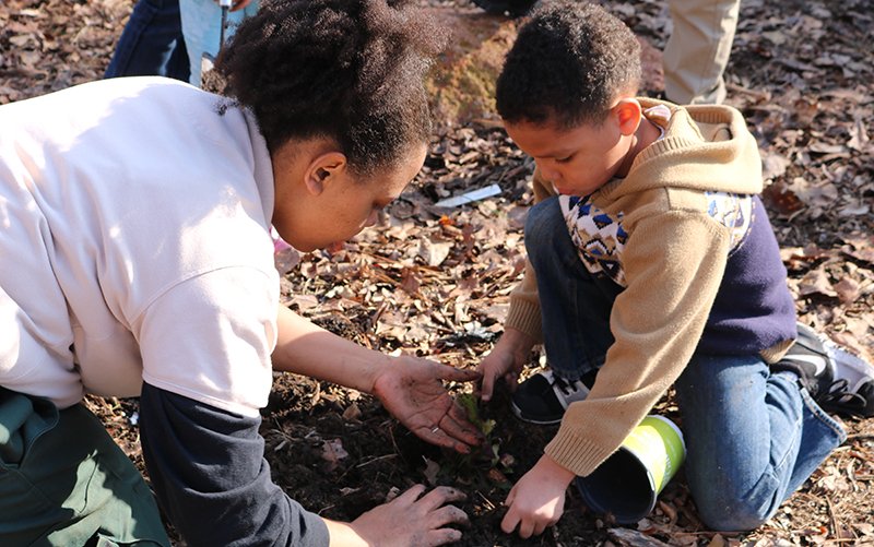 Submitted photo GARDENERS: Ouachita National Forest wildlife biologist Mary Brown, left, assists Science After School participant Ashton Mahomes in planting a pollinator garden in front of Mid-America Science Museum.