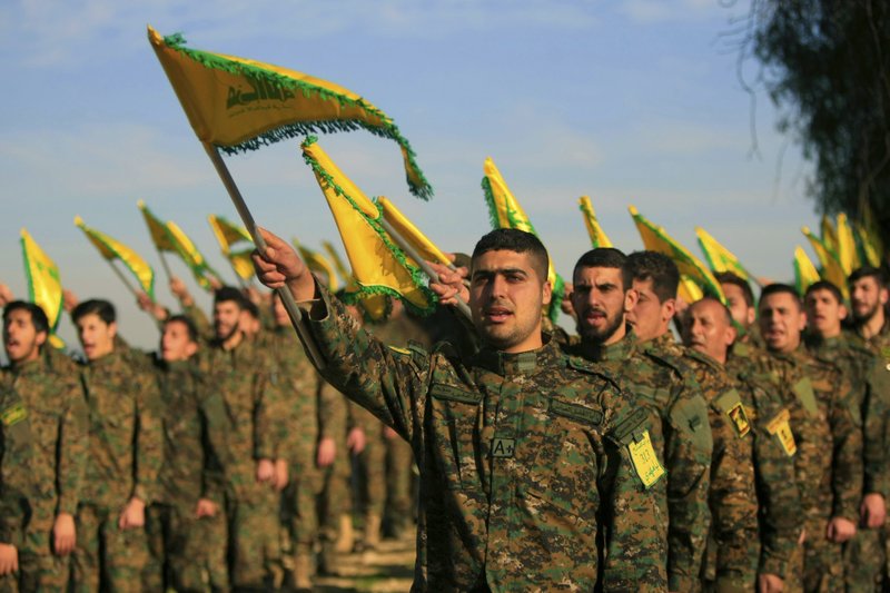  In this Feb. 13, 2016 file photo, Hezbollah fighters hold flags as they attend the memorial of their slain leader Sheik Abbas al-Mousawi, who was killed by an Israeli airstrike in 1992, in Tefahta village, south Lebanon. U.S. Secretary of State Mike Pompeo's visit to Lebanon this week is expected to underscore the Trump administration's displeasure with Hezbollah's growing influence in Lebanese politics. The Iranian-backed group wields more power than ever in the country's Cabinet and parliament. (AP Photo/Mohammed Zaatari, File)