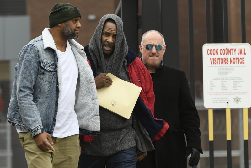 In this March 9, 2019 photo, singer R. Kelly center, walks with his attorney Steve Greenberg right, and an unidentified man left, who gave him a ride after being released from Cook County Jail, March 9, 2019, in Chicago. A Chicago judge is expected to rule on whether to let R. Kelly to travel overseas to perform several concerts to help the cash-strapped singer pay legal and other bills as he faces sex-abuse charges. A hearing Friday, March 22, follows a defense motion saying the 52-year-old singer hopes to do up to five April concerts in Dubai. (AP Photo/Paul Beaty, File)