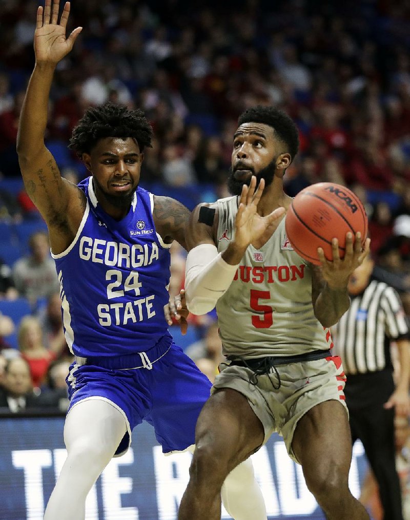 Houston’s Corey Davis Jr. heads to the basket as Georgia State’s Devin Mitchell defends during the second half of a Midwest Region first-round game of the NCAA Tournament on Friday in Tulsa. Corey Davis scored 26 points as Houston won 84-55.